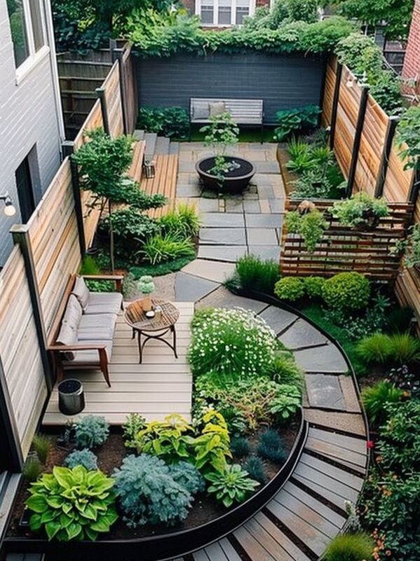 Beautiful backyard garden featuring curved pathways, wooden seating deck, lush green plants, and a central firepit area.